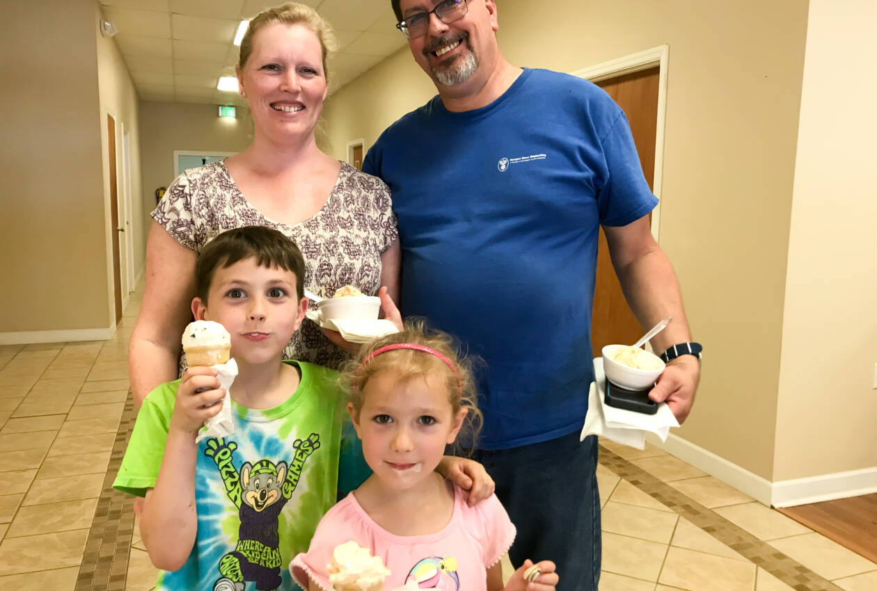 A family posing for the camera with ice cream.