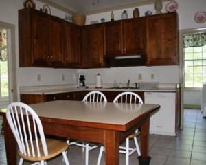 A kitchen with wooden cabinets and white tile floors.