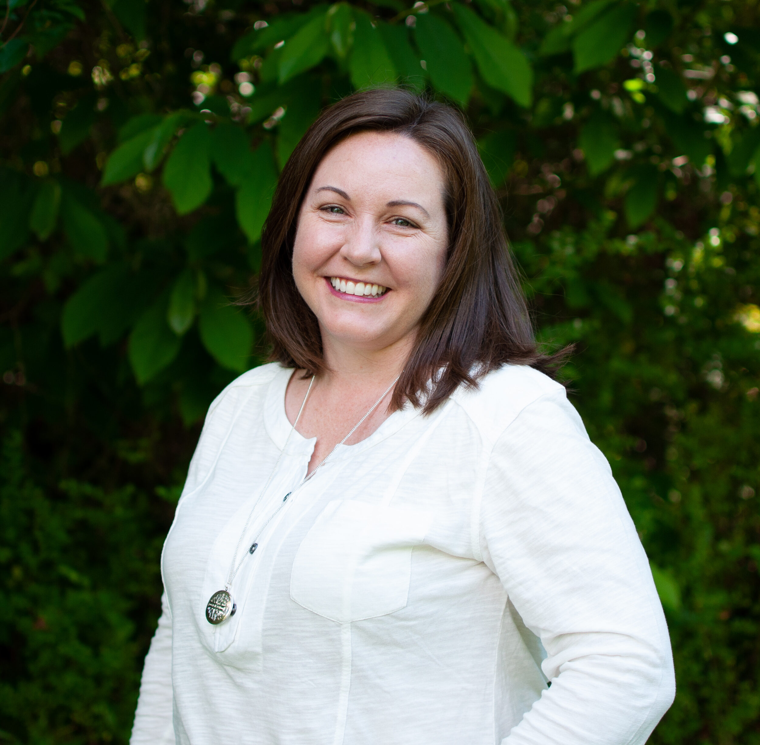 A woman standing in front of some trees