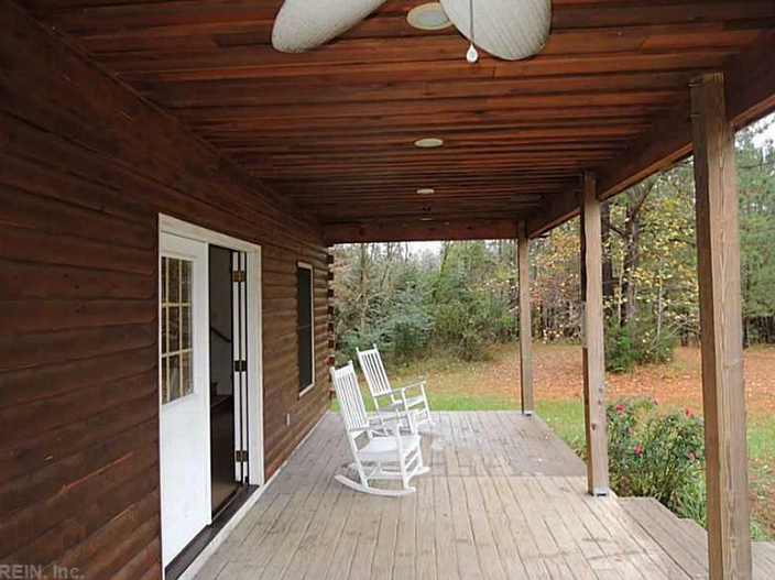 A porch with two rocking chairs and a ceiling fan.