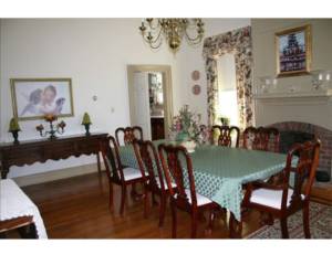 A dining room table with chairs and a fireplace.