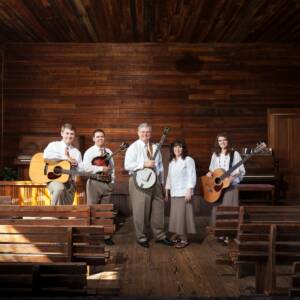 A group of people standing in front of a wooden wall.
