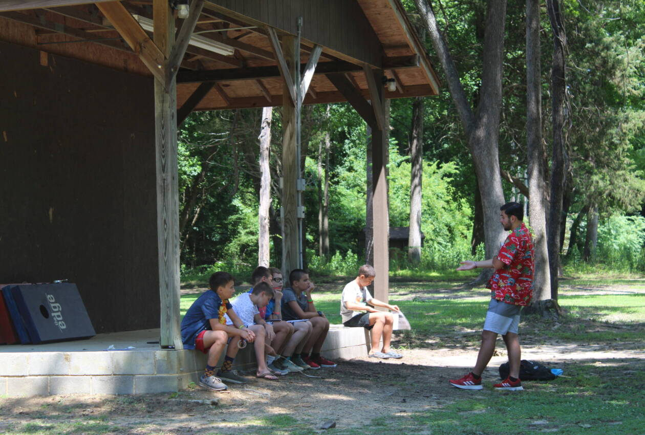 A group of people sitting under a pavilion.