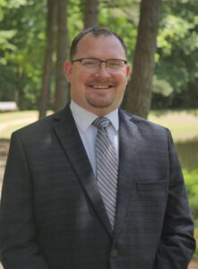 A man in a suit and tie standing outside.
