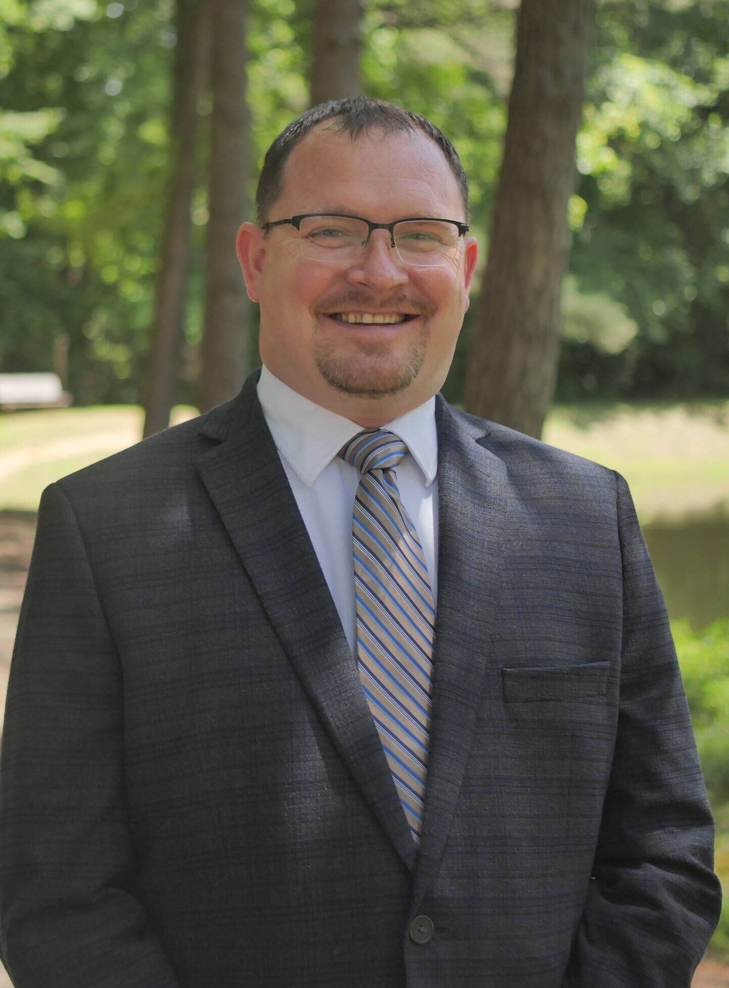 A man in a suit and tie standing outside.