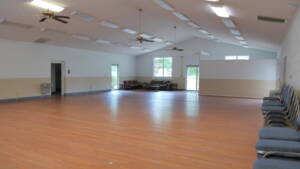 A large room with hard wood floors and ceiling fans.