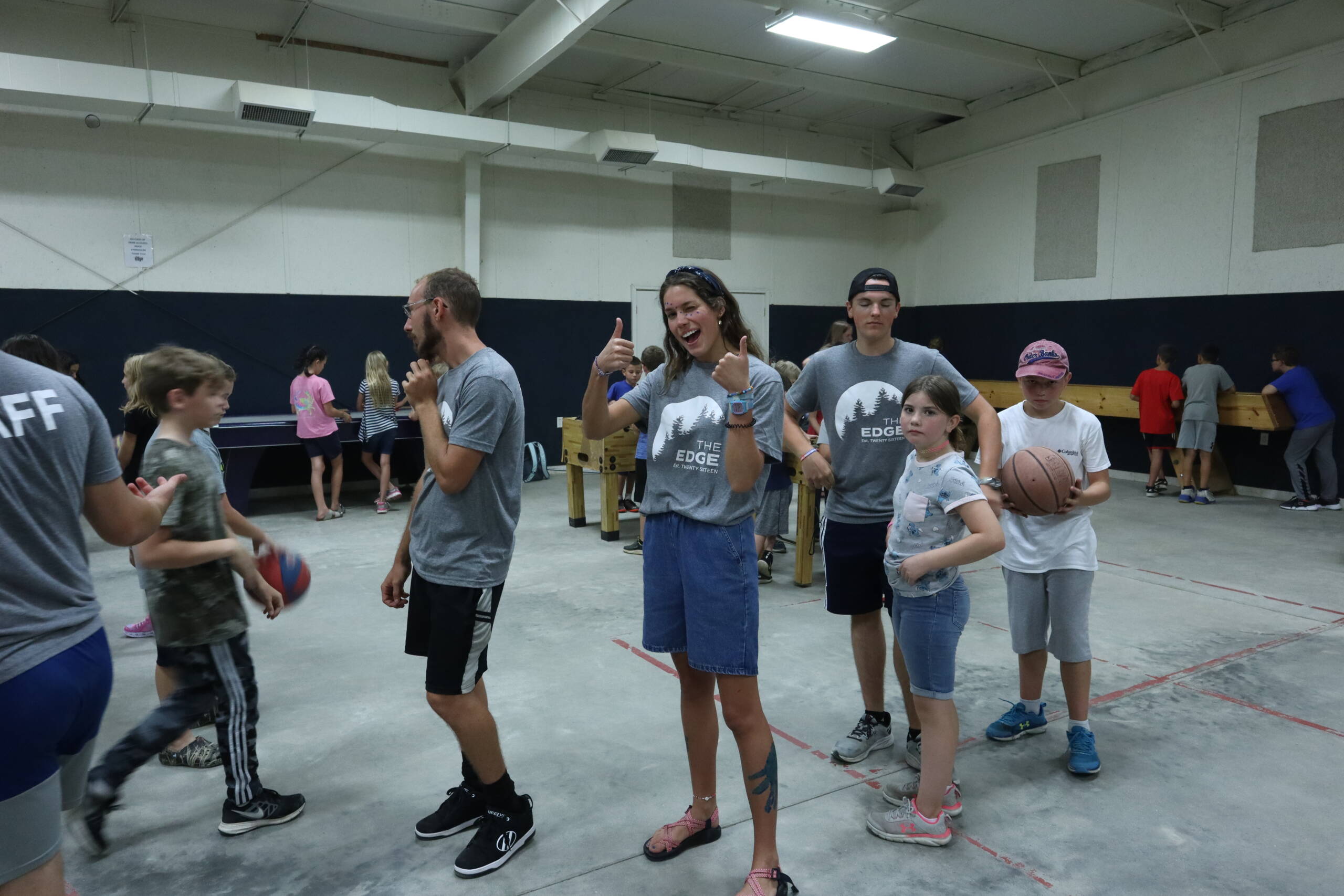 A group of people standing in a gym holding hands.