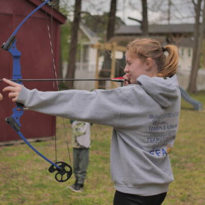 A girl is holding a bow and arrow