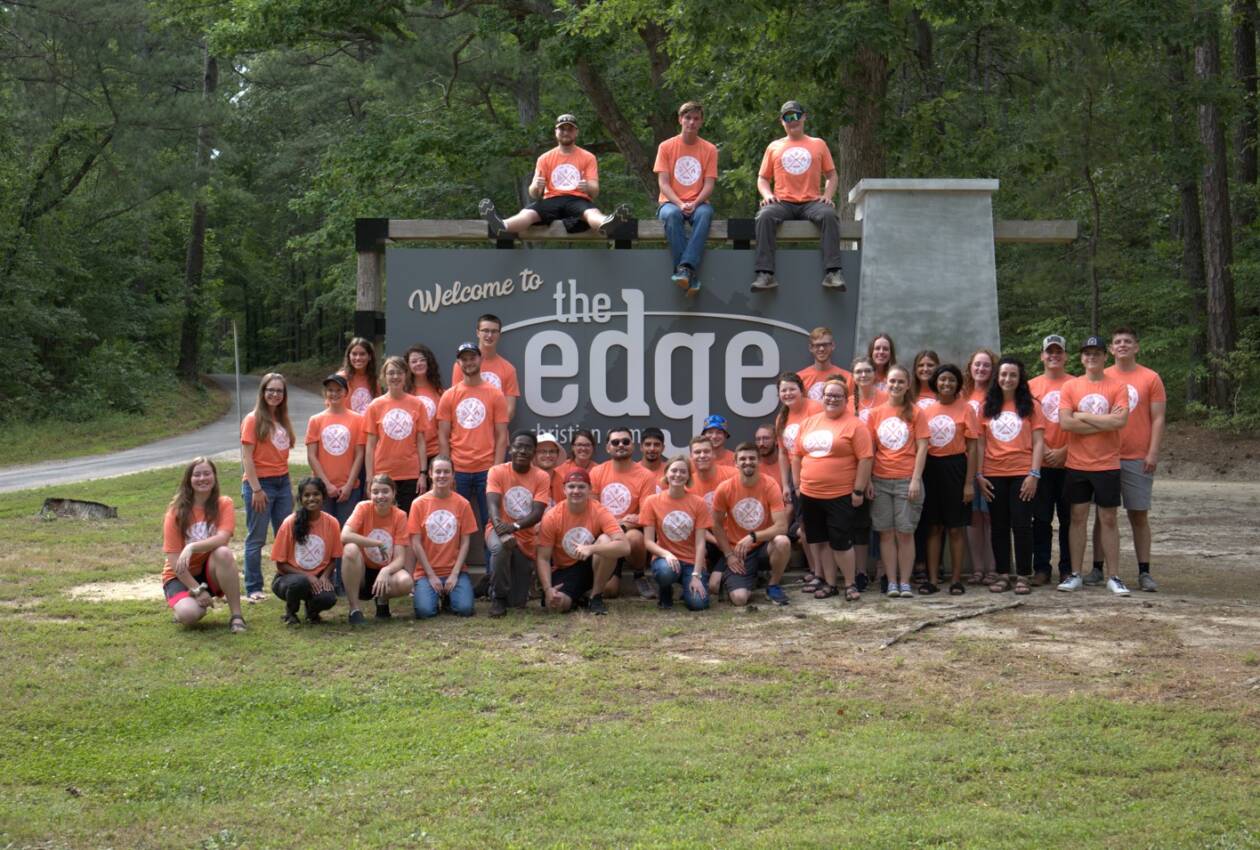 A group of people in orange shirts and jeans.