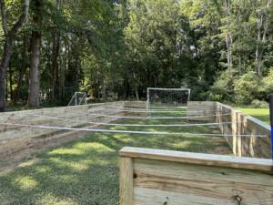 A small wooden soccer field surrounded by trees.